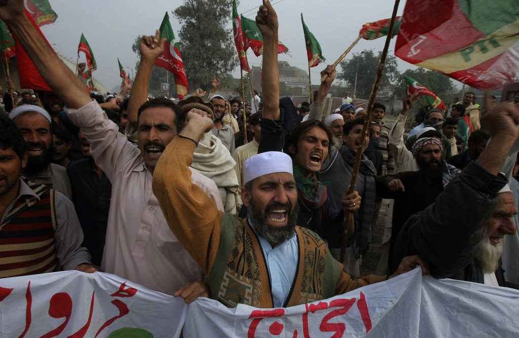 Supporters of Tehreek-e-Insaf or Movement for Justice party chant anti-U.S. slogans during a rally in Peshawar, Pakistan, on Saturday. Thousands of people protesting U.S. drone strikes blocked a road in northwest Pakistan used to truck NATO troop supplies and equipment in and out of Afghanistan, the latest sign of rising tension caused by the attacks.