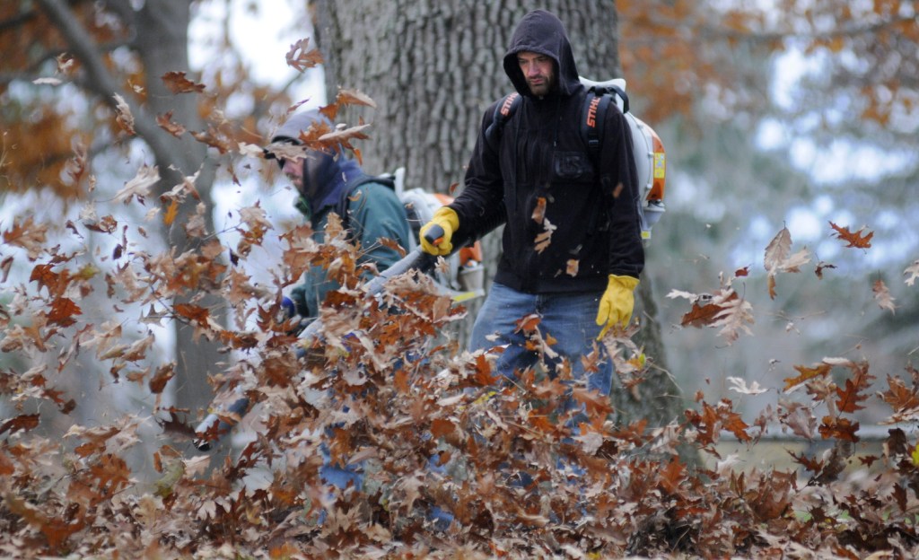 Bureau of General Services employees Tim Campbell, right, and Rik Hutchinson blow oak leaves Tuesday from Capitol Park In Augusta. The men and their colleague, Harold Eames, said working in cool, windy conditions was better than herding leaves on warm, humid days.