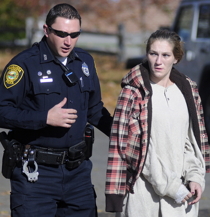 Staff photo by Andy Molloy APPREHEND: Augusta Police Officer Eric Lloyd escorts Gladys Fowler, 31, to a cruiser Wednesday after she was arrested at her Augusta home in connection with a burglary of an Augusta business.