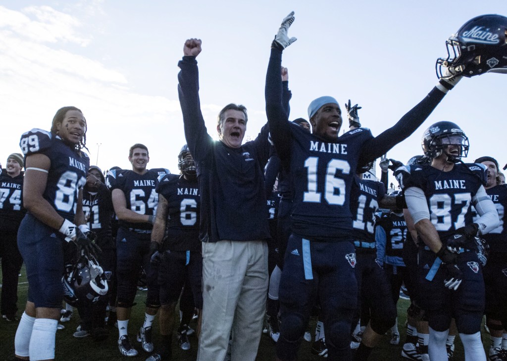 Maine football coach Jack Cosgrove celebrates with his players after defeating Rhode Island 41-0 in an NCAA football game in Orono, Maine, Saturday, Nov. 16, 2013. (AP Photo/Michael C. York)