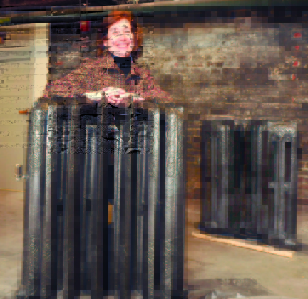 Staff photo by David Leaming NEW USE: Interior designer Lori Larochelle stands between two halves of radiators that were once used for heat in the Gerald Hotel in Fairfield. The units have been restored and will be joined together and a glass top added to make a table for flowers.