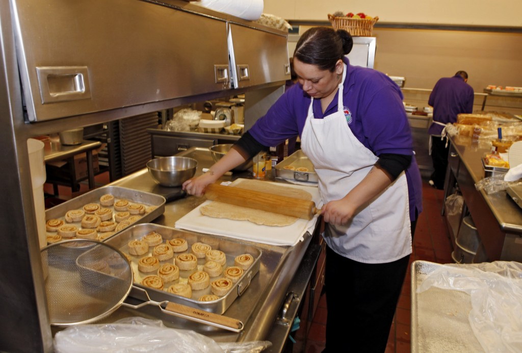 Alexes Garcia makes cinnamon rolls for students’ lunches in the kitchen at Kepner Middle School in Denver. The rolls are made using apple sauce instead of trans fats.
