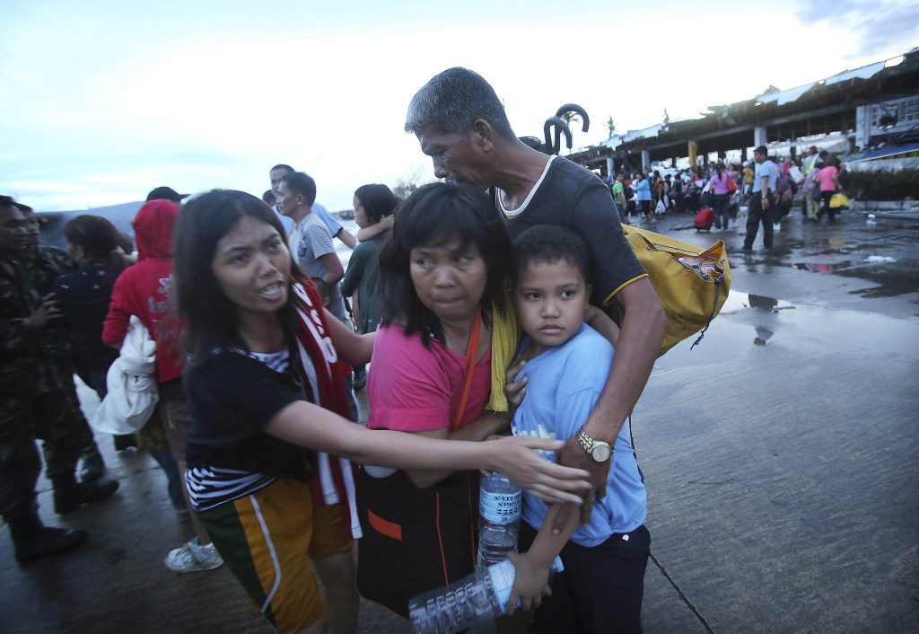 Survivors of Typhoon Haiyan comfort each other after not being allowed to board a C-130 cargo plane because of limited space, at the airport in Taclobanon Tuesday.