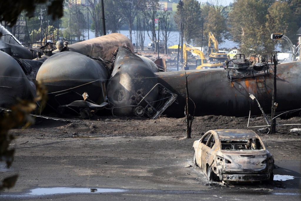 A burned out vehicle sits near the wreckage of tanker cars following the train derailment in Lac Megantic, Quebec, on July 7, 2013. U.S. railroads are supporting new safety standards for rail cars that haul flammable liquids to address flaws that can allow crude oil, ethanol and other substances to leak during accidents.