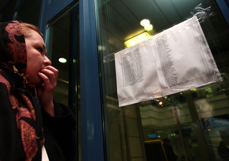 A woman reads a list with the names of passengers who were aboard an airliner that crashed in Kazan on Sunday.