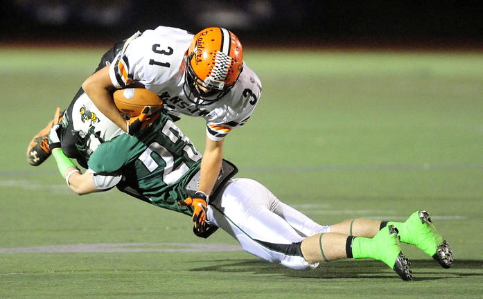 Staff photo by Michael G. Seamans CLASS C FOOTBALL:Leavitt High School's Nate Rousseau, 23, tackles Winslow High School's Richard Crayton, 31, in the second quarter in the Class C state championship game at Fitzpatrick Stadium in Portland on Saturday. Leavitt defeated Winslow 47-18.