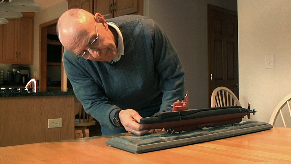 Michael Riegel, a former commander of the U.S. Navy Submarine Base in Groton, Conn., looks at a model of the research submarine NR-1, in his Preston, Conn. home. Now the Navy has collected pieces of the sub for an exhibit at a museum in Groton.