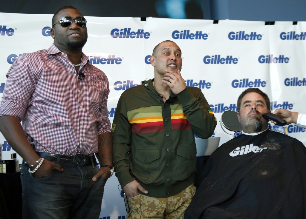 Boston police Officer Steve Horgan is shaved as Red Sox players David Ortiz, left, and Shane Victorino, center, look on during a shave-off for One Fund Boston, the Boston Marathon charity for bombing victims, in Boston on Monday.