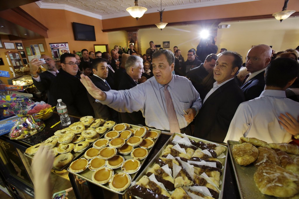 New Jersey Gov. Chris Christie waves to workers at Oasis Pastry Shop during a campaign stop in Hillside, N.J., Monday, Nov. 4, 2013. Christie will face Democratic candidate, Barbara Buono in an election Tuesday, Nov. 5, 2013. (AP Photo/Mel Evans)