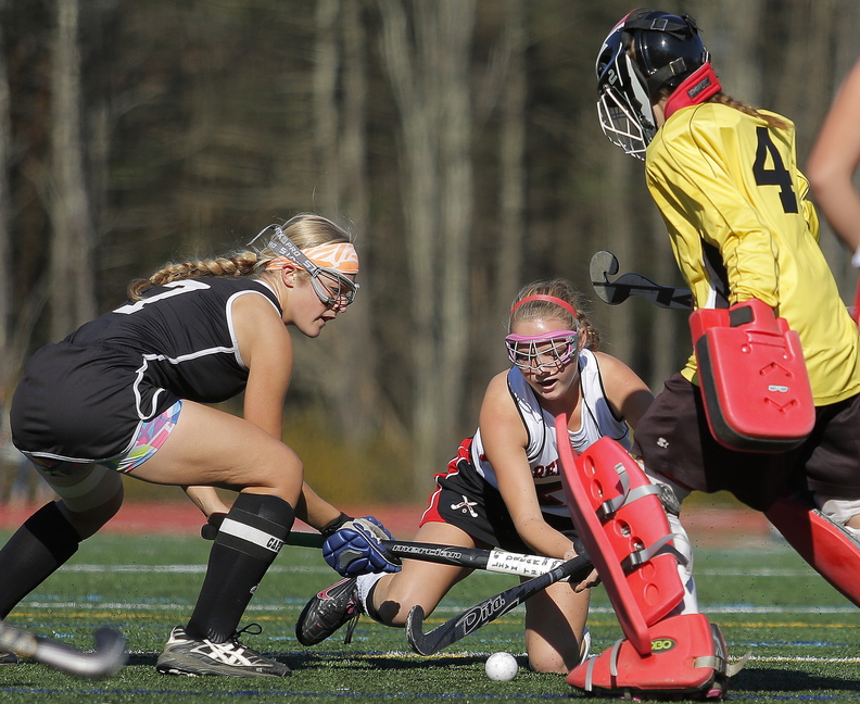 IN CLOSE: Skowhegan’s Mikayla Toth, left, battles Scarborough’s Ashley Levesque for control of the ball as Skowhegan goalie Leah Kruse gets in on the action during first half play in the Class A field hockey state championship Saturday at Yarmouth High School.