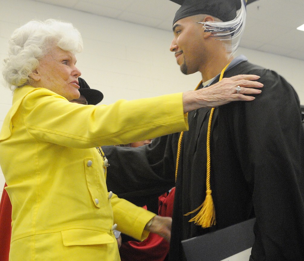 Accomplishment: Maine State Prison inmate Sergio Hairston hugs philanthropist Doris Buffett on Monday after he received his diploma from the University of Maine at Augusta during a graduation ceremony at the prison in Warren. A total of 14 men incarcerated at the prison received diplomas. Buffett, the sister of legendary investor Warren Buffett, founded the Sunshine Lady Foundation that supports educating inmates across the United States.