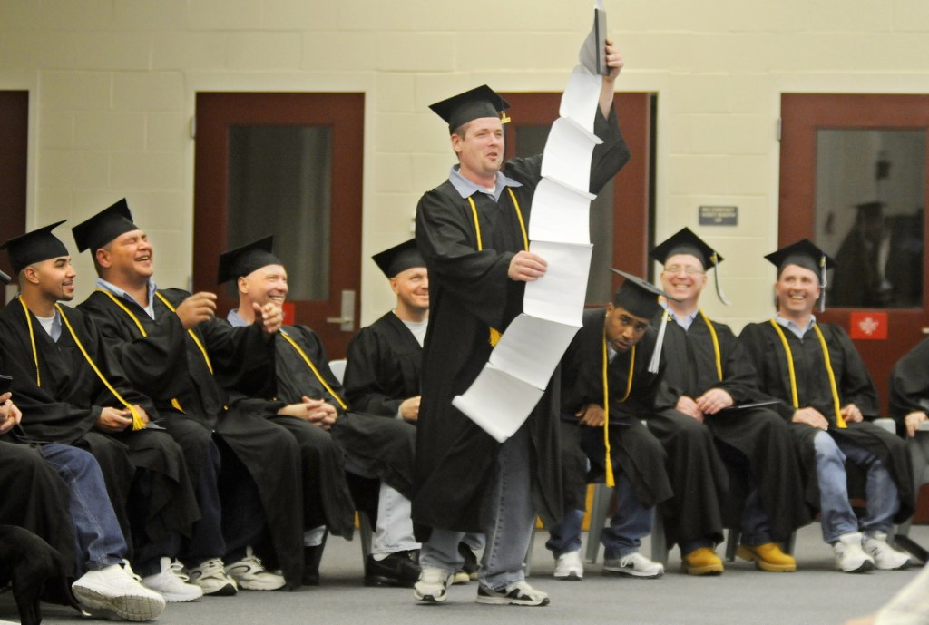 Thankful: Maine State Prison inmate Steven Clark holds up a speech about everyone he wanted to thank Monday after he and 13 other men incarcerated at the Warren prison received their diplomas from the University of Maine at Augusta.
