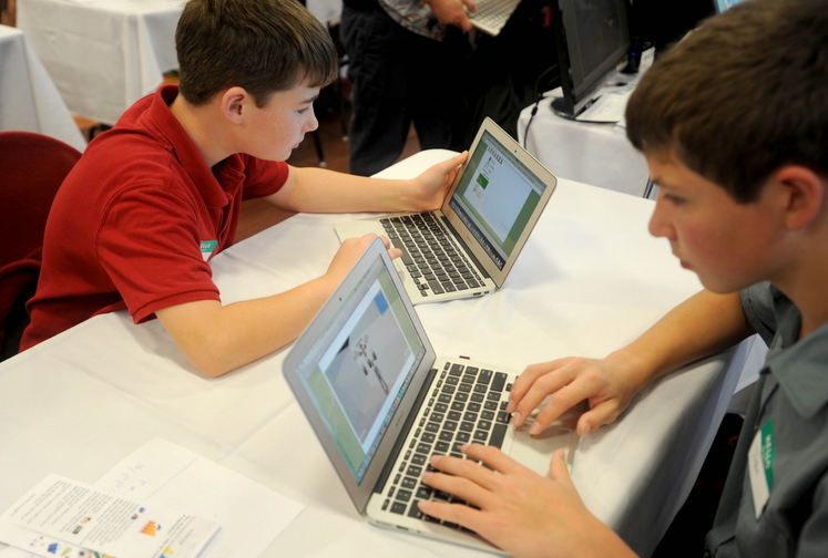 computer skills: Monmouth Middle School students, Trevor Flanagan, 12, left, and Dylan Goff, 14, demonstrate their computer skills during a Kennebec Valley area high school expo at Thomas College on Friday morning. Students and teachers from Kennebec Valley school districts gathered in Waterville to show off their accomplishments.