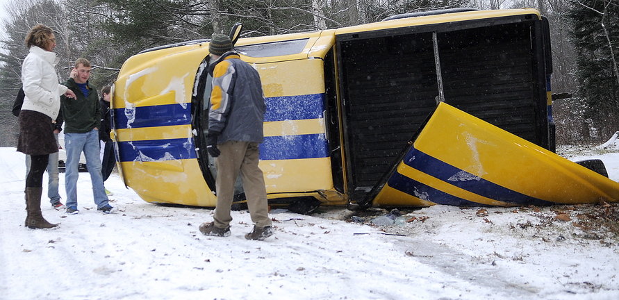 ROLLOVER: Dr. Dean Chamberlain, right, checks on passengers of a pickup that rolled over Tuesday morning on Shady Lane in Hallowell. Several accidents were reported across the state after the first snow to accumulate on roads fell Tuesday morning. Chamberlain, a resident at the Family Medical Institute at MaineGeneral Medical Center, was told nobody was injured in the rollover on slushy roads.