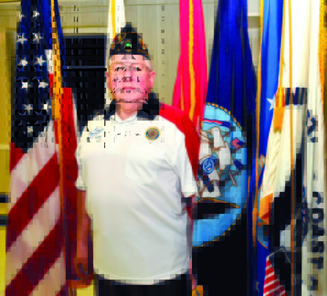 PATRIOT: Ernest Paradis, commander of the Bourque Lanigan Post 5 American Legion in Waterville, stands among flags including the American and the five branches of the armed services.