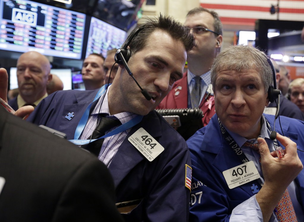 Traders Gregory Rowe, left, and Richard Newman confer on the floor of the New York Stock Exchange on Wednesday.