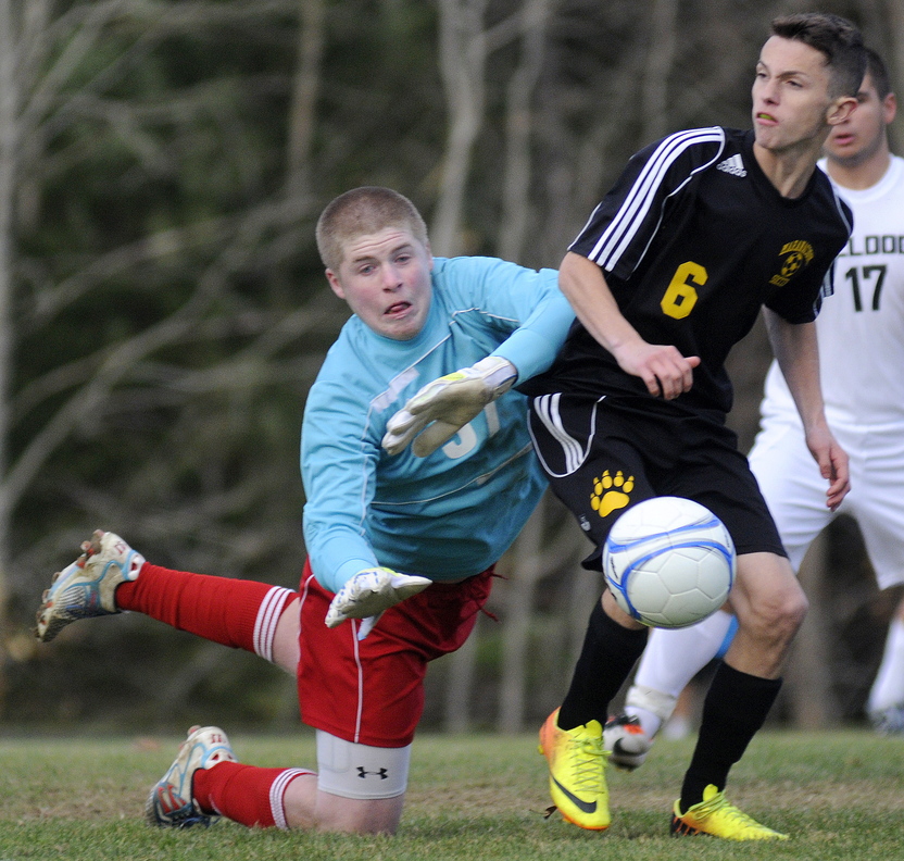 Staff photo by Andy Molloy Hall-Dale High School keeper Brian Allen knocks a ball away from Maranacook Community High School's Kodey Solmitz during the Class C Western soccer title game Wednesday in Farmingdale. Maranacook prevailed 1-0.