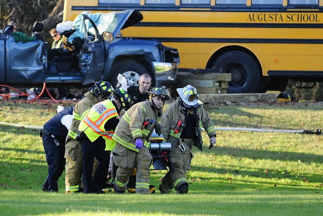 Emergency crews move the pickup truck driver: toward a LifeFlight helicopter at the scene of a crash involving an Augusta school bus and pickup truck Tuesday on Riverside Drive, just south of Stevens Road, in Augusta.