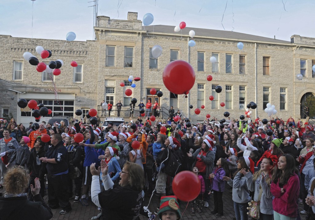Balloons are released as a large crowd sings Christmas carols outside of Devin Kohlman’s home in Port Clinton, Ohio, on Oct. 28.
