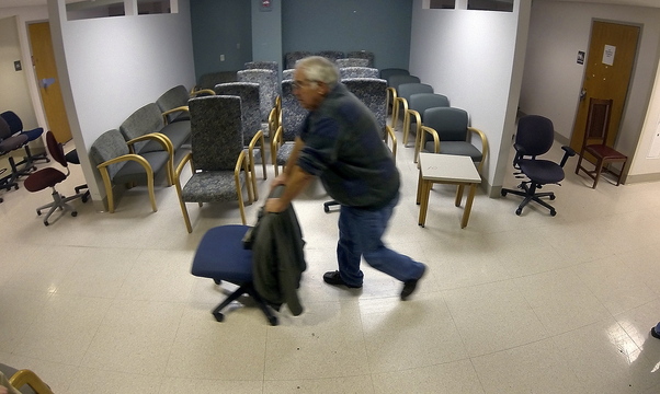 Rolling away: Mike Thomas, of Monmouth, rolls a desk chair down a hallway during the public sale of items from the former MaineGeneral Medical Center on Saturday on East Chestnut Street in Augusta.