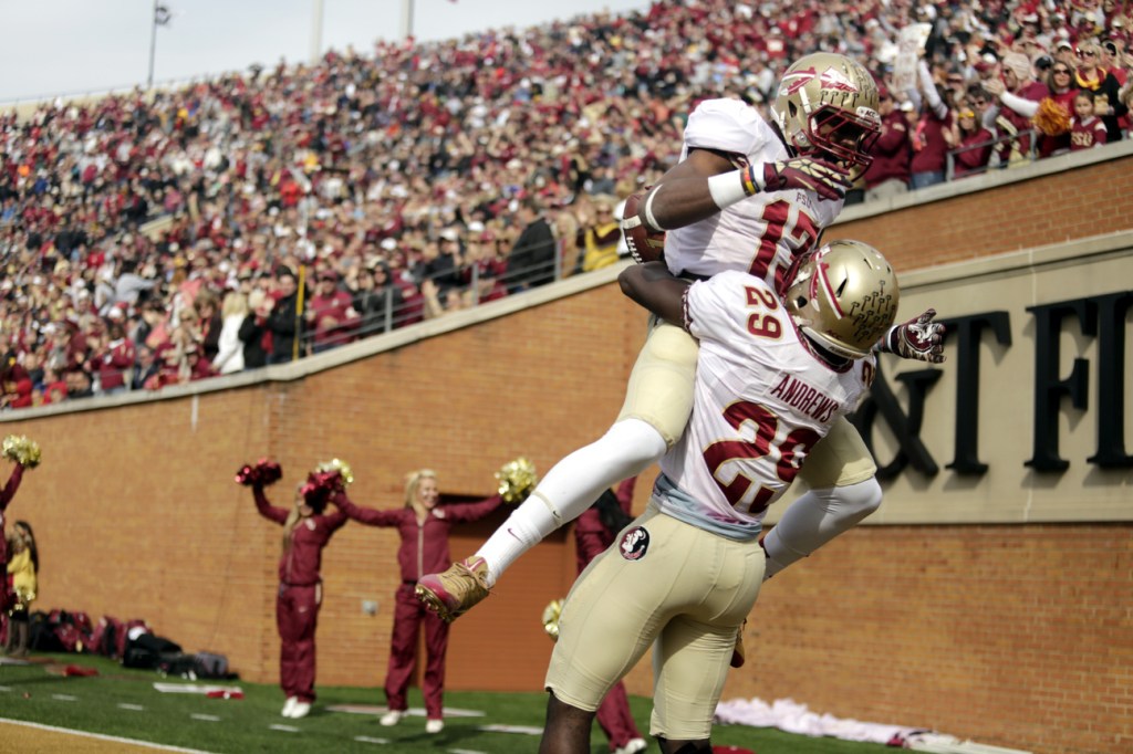 Florida State defensive back Jalen Ramsey, top, jumps into the arms of teammate Nate Andrews after Andrews ran back an interception for a touchdown against Wake Forest in the first half of an NCAA college football game in Winston-Salem, N.C., Saturday, Nov. 9, 2013. (AP Photo/Nell Redmond)
