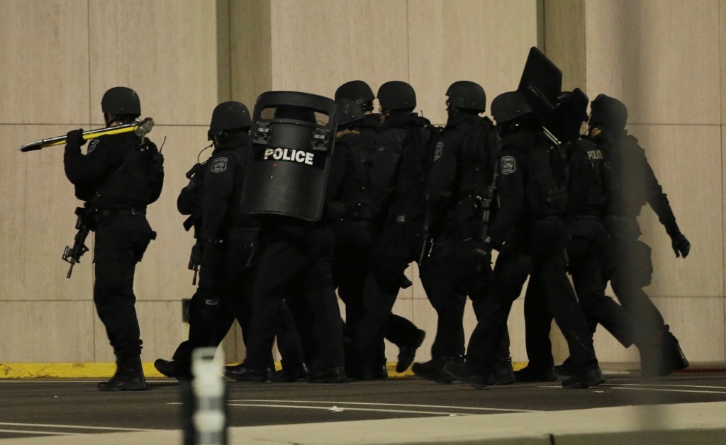Officials wearing tactical gear walk outside of Garden State Plaza Mall following reports of a shooter in Paramus, N.J. Hundreds of law enforcement officers converged on the mall Monday night after witnesses said multiple shots were fired there.