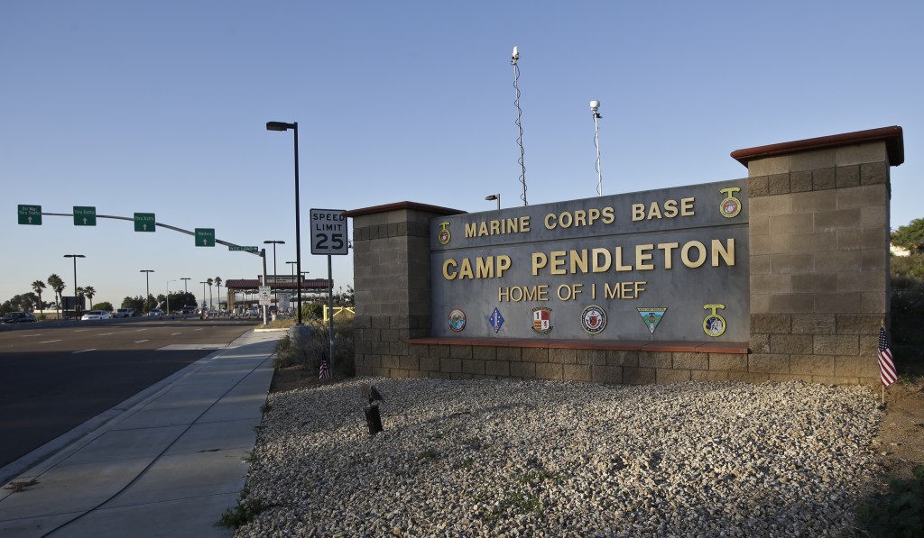 Vehicles file through the main gate of Camp Pendleton Marine Base on Wednesday, Nov. 13, 2013, at Camp Pendleton, Calif. Four Marines were reported killed today in an accident while clearing an unexploded ordnance.