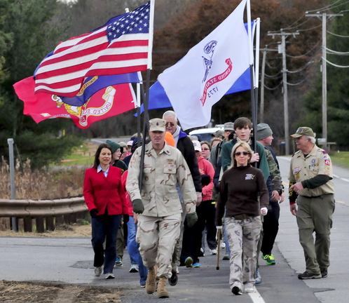 MARCH OF HONOR: Kennebec County Sheriff Randall Liberty leads a group of veterans and supporters as they march through Winslow toward Waterville to take part in the Veterans Day parade on Monday, Nov. 11, 2013. At right is his wife Jodi. Kennebec District Attorney Maeghan Maloney is at left.