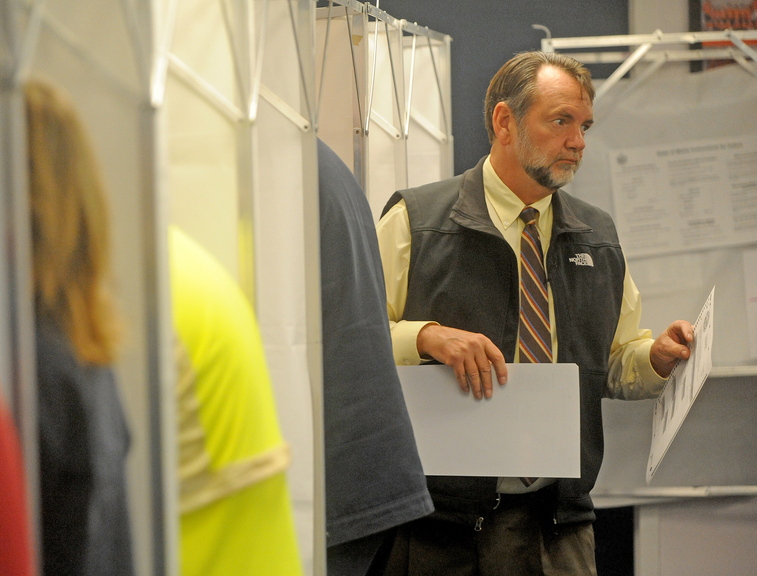 Lakefront vote: Milt Dudley, exits the voting booth after casting a ballot at the China Town Office on Tuesday. Voters turned out to decide whether to buy lakefront property and to elect town officials.