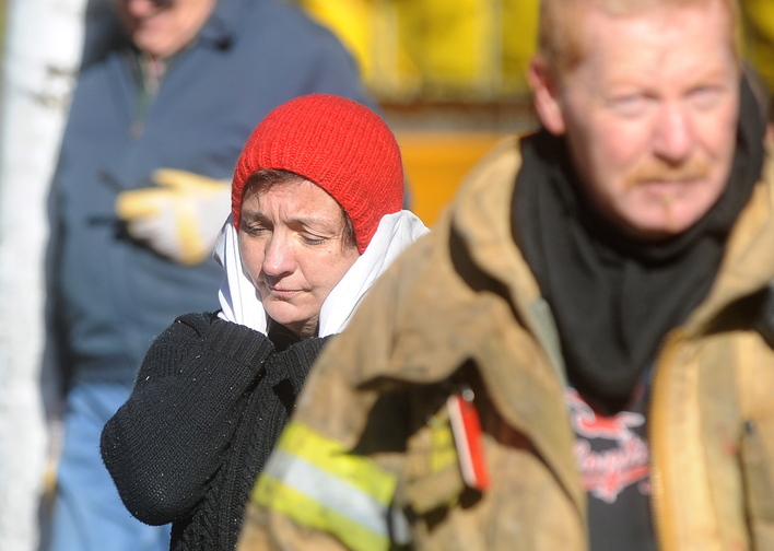 UNINJURED: Laura Ellis reacts after she escaped injury when her car caught fire and spread to the trailer she was staying in on Beach Road in South China on Tuesday morning.