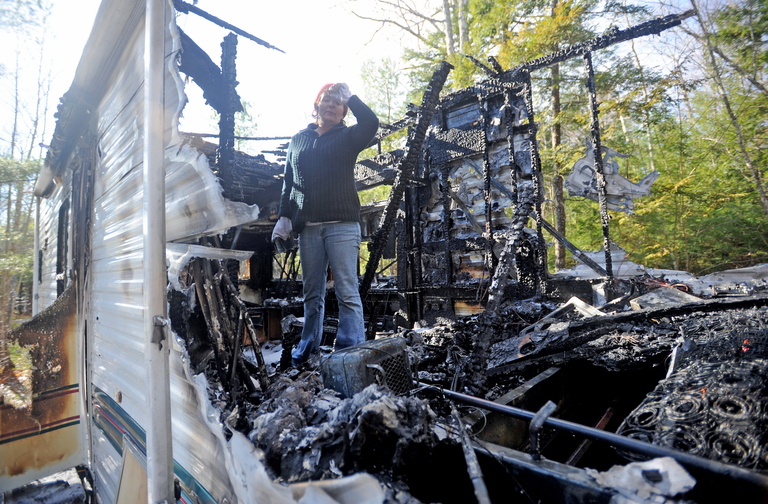 Burned: Laura Ellis investigates the damage to the camper trailer she was staying in on Beach Road in South China on Tuesday morning.