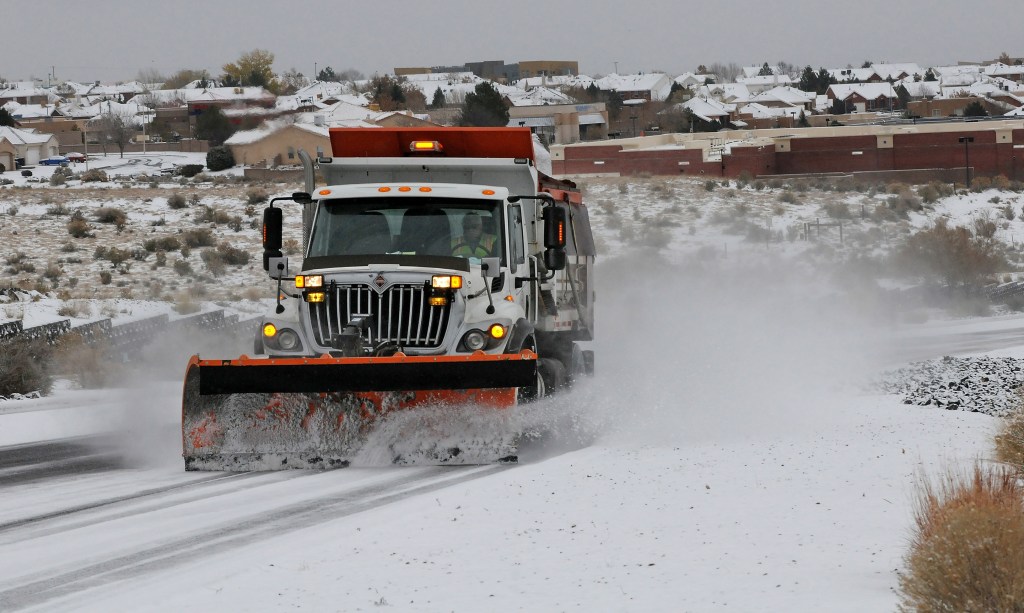 A Deptartment of Transportation plow and sanding truck heads up Paseo del Norte in Albuquerque, N.M., Sunday, Nov.24, 2013, in Albuquerque, N.M., after a winter storm hit New Mexico over the weekend making driving difficult. A large storm already blamed for at least eight deaths in the West slogged through Oklahoma, Texas, New Mexico and other parts of the southwest Sunday as it slowly churned east ahead of Thanksgiving.