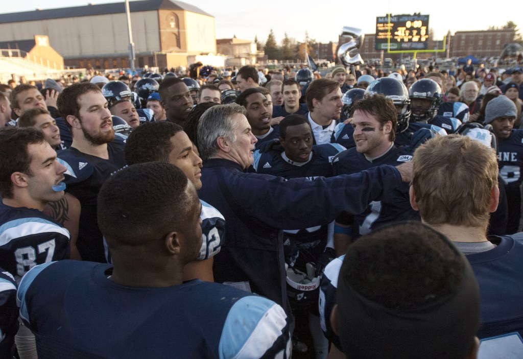 CELEBRATE: Maine football coach Jack Cosgrove, center, celebrates with his players after winning the regular season championship in the CAA with a 41-0 win over Rhode Island 41-0 Saturday in Orono.