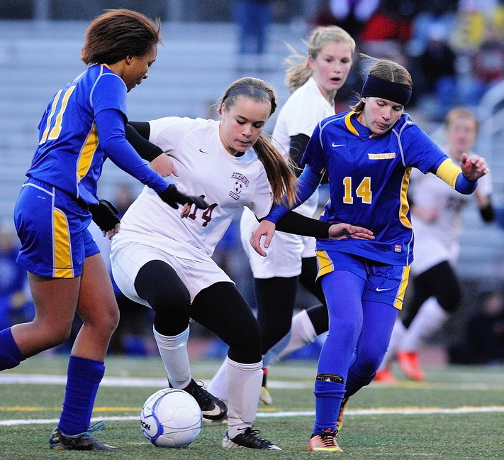 Staff photo by Joe Phelan Richmond forward Amber Loon, middle, is double teamed by Washburn defender Tyra Shaw, left, and midfielder Kennedy Churchill during the state class D soccer championship game on Saturday November 9, 2013 at McMann Field in Bath.
