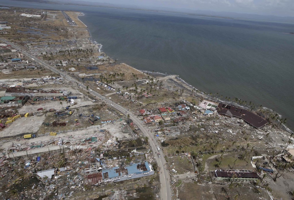 This aerial photo taken from a Philippine Air Force helicopter shows the devastation caused by Typhoon Haiyan in Tacloban city, Leyte province, central Philippines, Monday, Nov. 11, 2013. Typhoon-ravaged Philippine islands faced an unimaginably huge recovery effort that had barely begun Monday, as bloated bodies lay uncollected and uncounted in the streets and survivors pleaded for food, water and medicine. (AP Photo/Bullit Marquez)