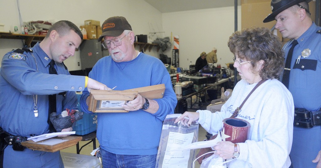 RECOVERED: State police Troopers Aaron Turcotte, left, and Bill Plourde help Henry and Andrea Trefethen inventory items they found Wednesday at the Kennebec County Sheriff’s Office in Augusta. Hundreds of stolen pieces of property recovered from a Wayne burglary ring were returned to victims. Several household items from the Trefethens’ camp on Parker Pond in Fayette were discovered in the loot seized by deputies and troopers.