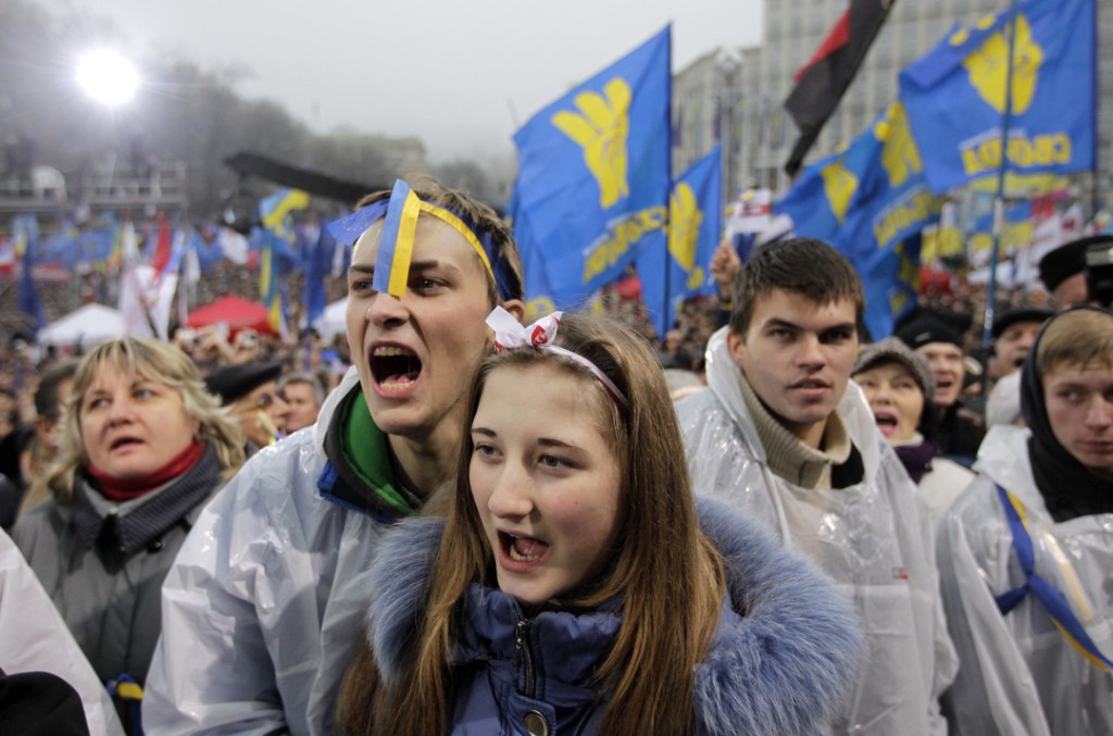 Demonstrators shout slogans during a protest in Kiev, Ukraine, Sunday, Nov. 24, 2013. Tens of thousands of demonstrators marched through central Kiev on Sunday to demand that the Ukrainian government reverse course and sign a landmark agreement with the European Union in defiance of Russia. The protest was the biggest Ukraine has seen since the peaceful 2004 Orange Revolution, which overturned a fraudulent presidential election result and brought a Western-leaning government to power. (AP Photo/Sergei Chuzavkov)