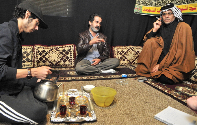 Coming to Augusta: Youssof Zamat, left, pours tea while Ghazi Yousif, center, answers questions during an interview last week at the apartment of Khalid Zamat, right, in Augusta.