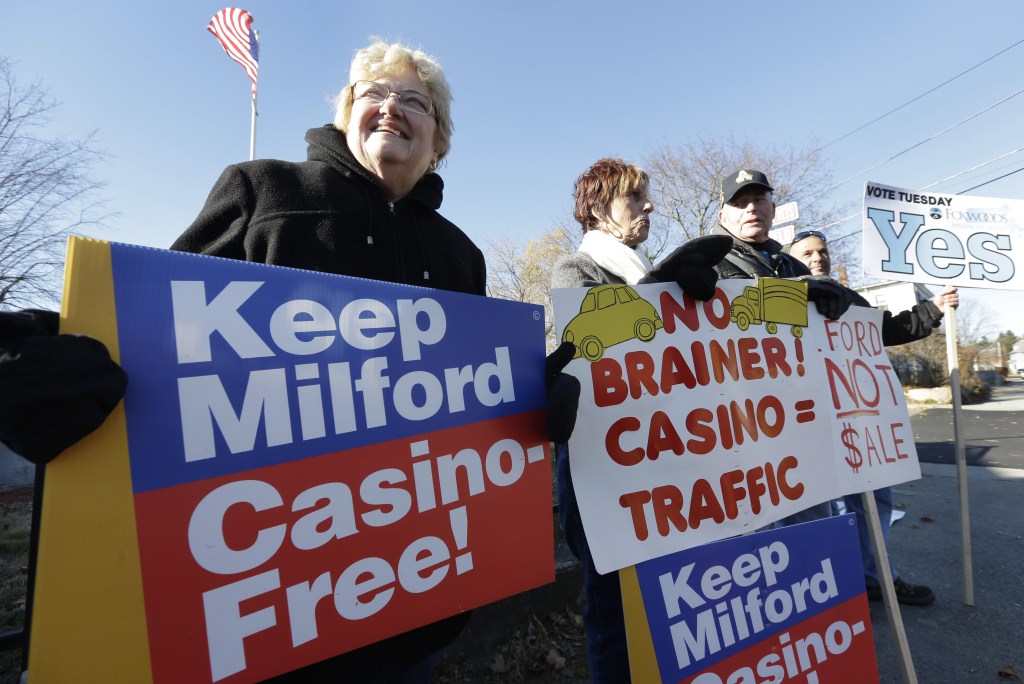 Mary Castrucci, left, and Rosemary Trettel, center, both of Milford, Mass., display placards outside a polling place Tuesday, Nov. 19, 2013, in Milford. The town’s residents were deciding whether to put out the welcome mat for a proposed $1 billion resort casino that would have been built off Interstate 495.