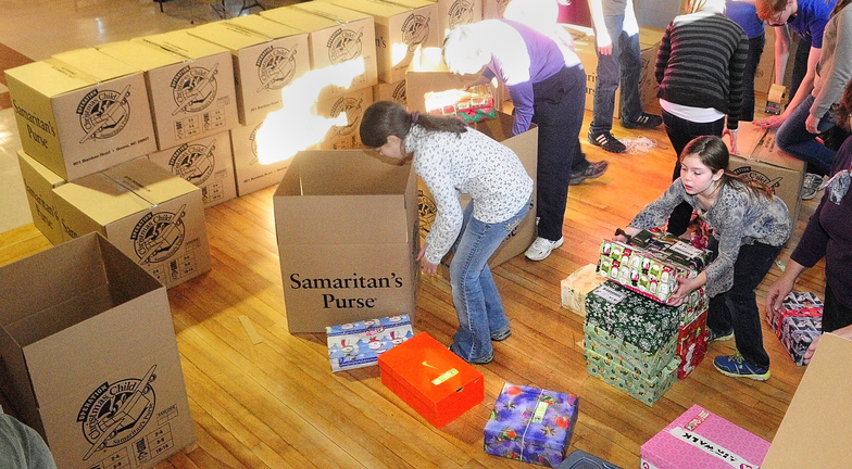 Giving: Mary Farrar, bottom right, and other volunteers from a church group from Peru put shoe boxes of gifts into shipping boxes on Saturday at Penney Memorial Baptist Church in Augusta. Pam Cullen said that there had been about 1,500 shoe boxes dropped of by Saturday and that more were expected to come in before they’re shipped out Monday morning. The Operation Christmas Child is a project of the Samaritan’s Purse and boxes will be distributed around the country and world.