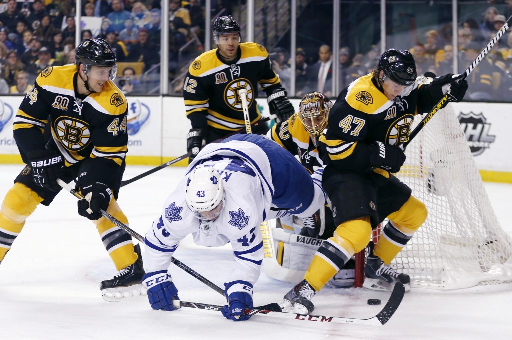 Toronto Maple Leafs’ Nazem Kadri (43) falls while battling Boston Bruins’ Torey Krug (47) and Dennis Seidenberg (44), of Germany, for the puck in the first period of an NHL hockey game in Boston, Saturday, Nov. 9, 2013.