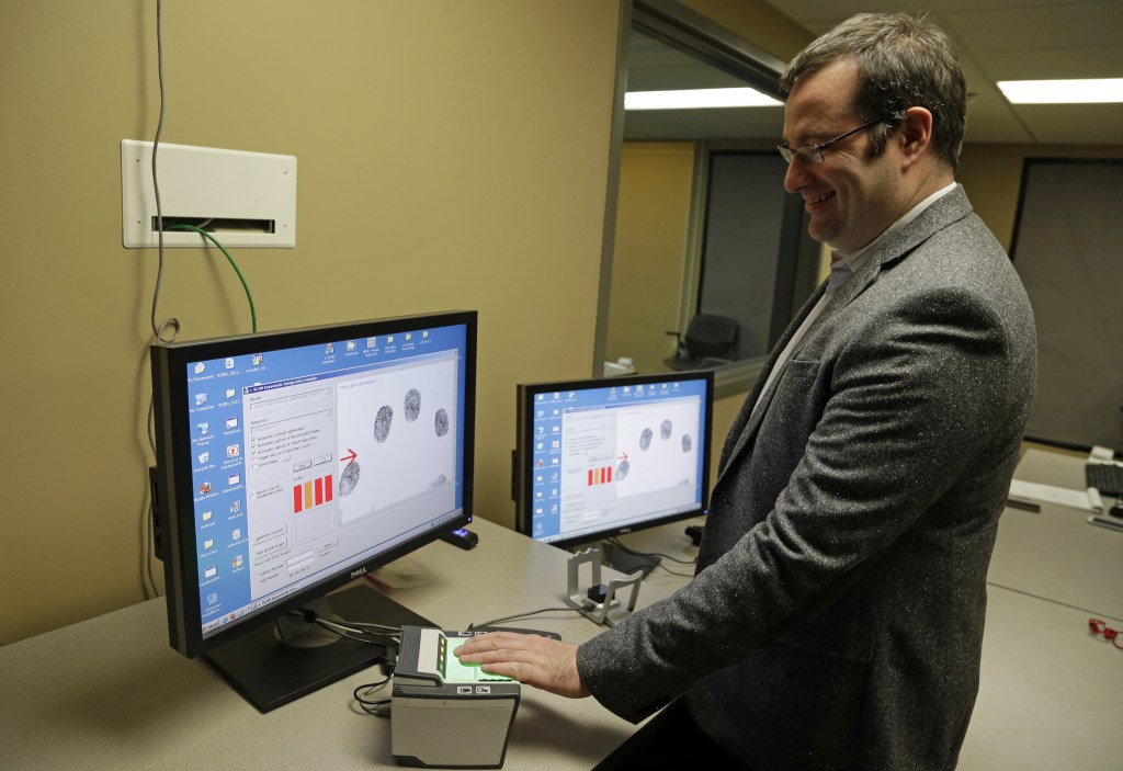 Stephen Elliott, director of international biometric research at Purdue University, demonstrates a fingerprint recognition system at one of his biometric labs last month in West Lafayette, Ind. Automated recognition of individuals based on their unique behavioral and biological characteristics is going mainstream and being studied by Elliott.