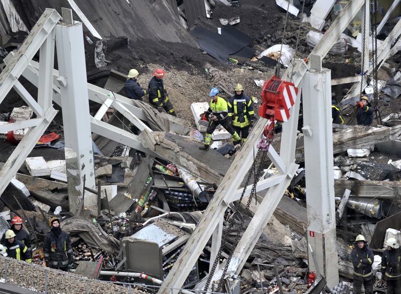 Rescue workers search debris of the Maxima supermarket in Riga, Latvia, Friday. At least 32 people died, including three firefighters, after a section of roof collapsed at a Latvian supermarket in the country’s capital, emergency medical officials said.