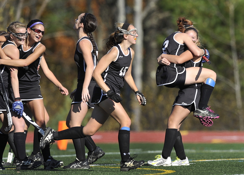 CELEBRATION TIME: Skowhegan’s Renee Wright, (2) and Emily Trial, (23) embrace at far right as they celebrate their victory over Scarborough during the Class A field hockey state championship game at Yarmouth High School.