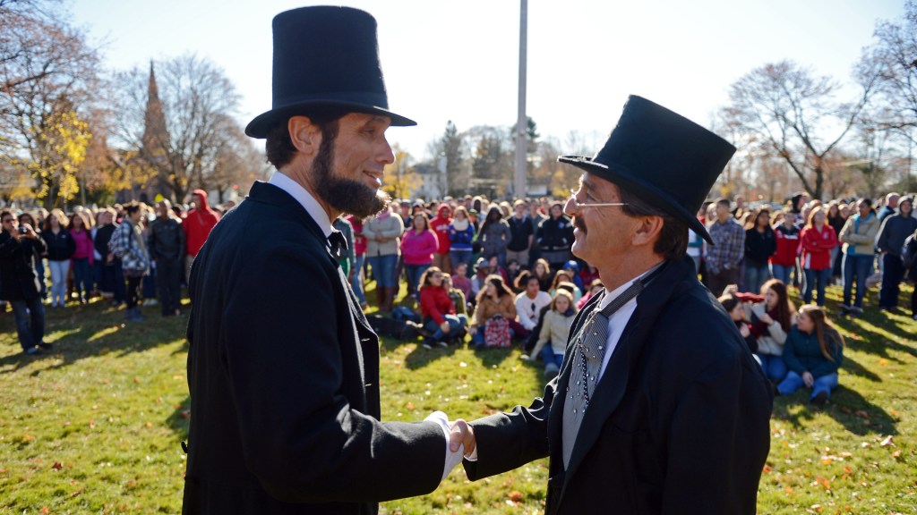 Abraham Lincoln re-enactor Howard Wright, left, is greeted by Norwich Free Academy Director of Student Affairs John Iovino on Chelsea Parade in Norwich, Conn., for an event to mark the 150th anniversary of the Gettysburg Address Tuesday, Nov. 19, 2013. Wright was introduced by Iovino and delivered prefacing remarks about Gettysburg and Lincoln’s words before reciting the actual speech.