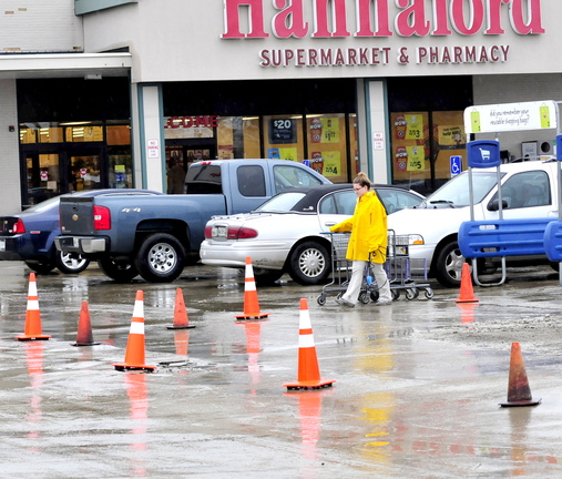 BOILED: A Hannaford employee gathers shopping carts Thursday at Elm Plaza in Waterville near a sectioned-off area where workers repaired an underground water main break on Wednesday. The Kennebec Water District ordered customers there to boil drinking water.