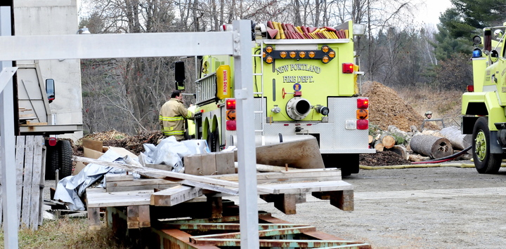 CLOSE CALL: New Portland Fire Chief Kip Poulin speaks with firefighters as piles of wood chips are taken out of JR Fabricating business on Sunday. Poulin said there was a fire earlier in the wood furnace system that brought several departments and firefighters to the scene off the River Road.