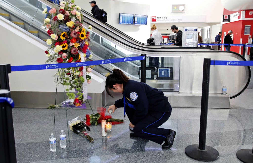 Transportation Security Administration Officer Alexa Mendoza lights a candle at a memorial to TSA officers killed and wounded at Terminal 3 at Los Angeles International Airport on Monday. TSA Officer Gerardo I. Hernandez was killed and two officers and one civilian wounded in the shooting at Terminal 3 on Friday.