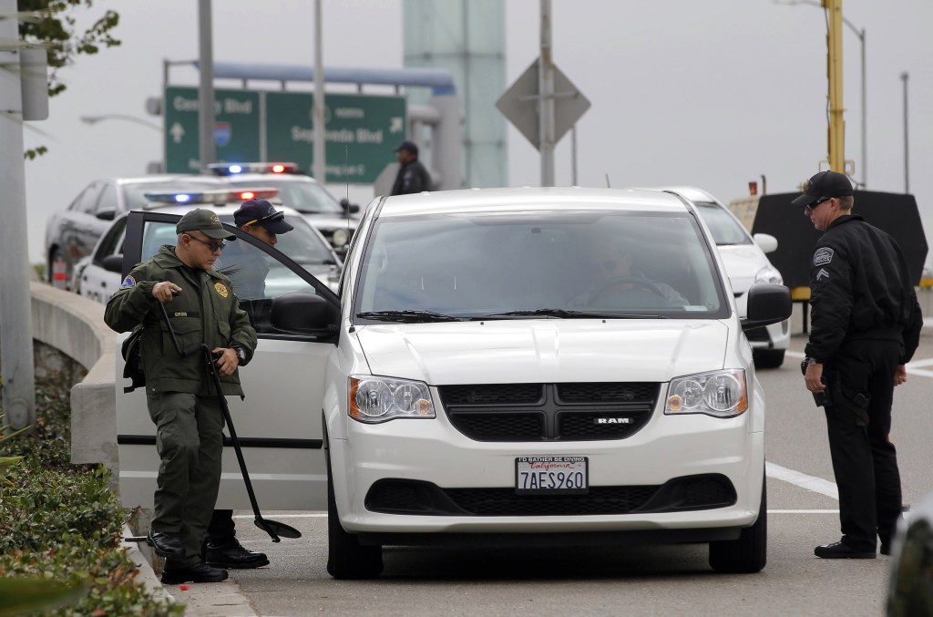 Security officers check a vehicle at a perimeter access road to Los Angeles International Airport on Monday. Operations at the airport were back to normal Monday, the first business day since a gunman killed a TSA agent there.