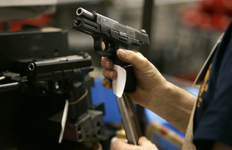 In this 2006 file photo, an employee loads a magazine into the grip of a model 9VE pistol while test firing at the Smith & Wesson factory in Springfield, Mass. Smith & Wesson says it will eliminate 37 jobs from its Houlton, Maine plant as it shifts the location’s focus to polymer-frame handguns and moves some manufacturing to its Springfield location.